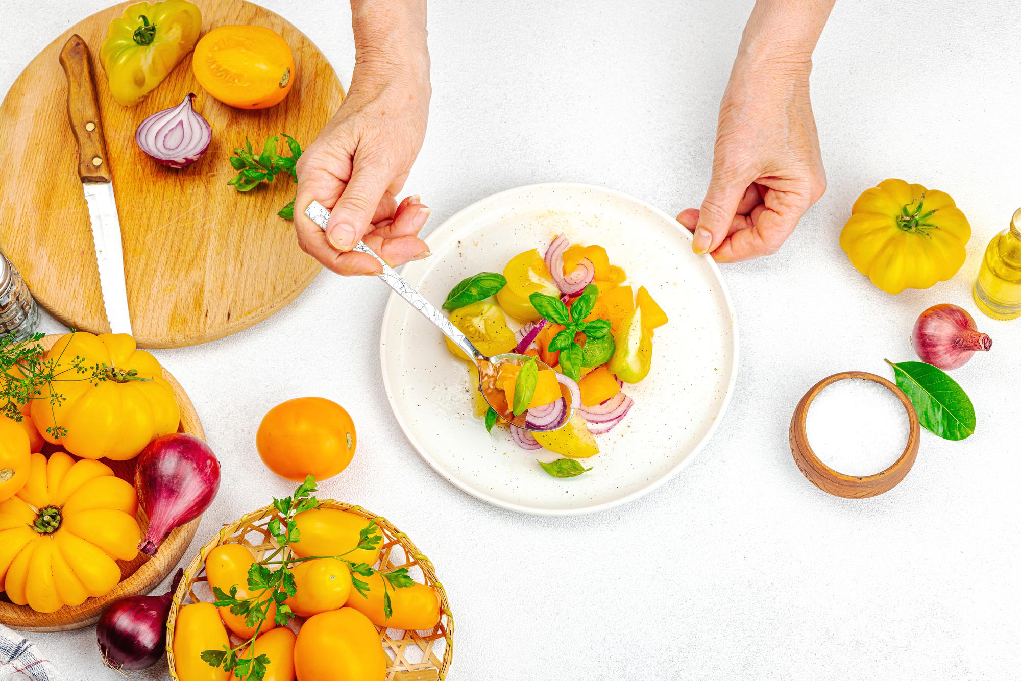 Chef arranging a colorful seasonal dish on wooden table